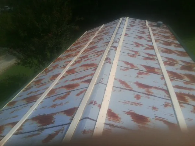 Rusted metal roof panels with new wood purlins before replacement — Storm Damage Roof Repair in Archbald by Roofing Brothers