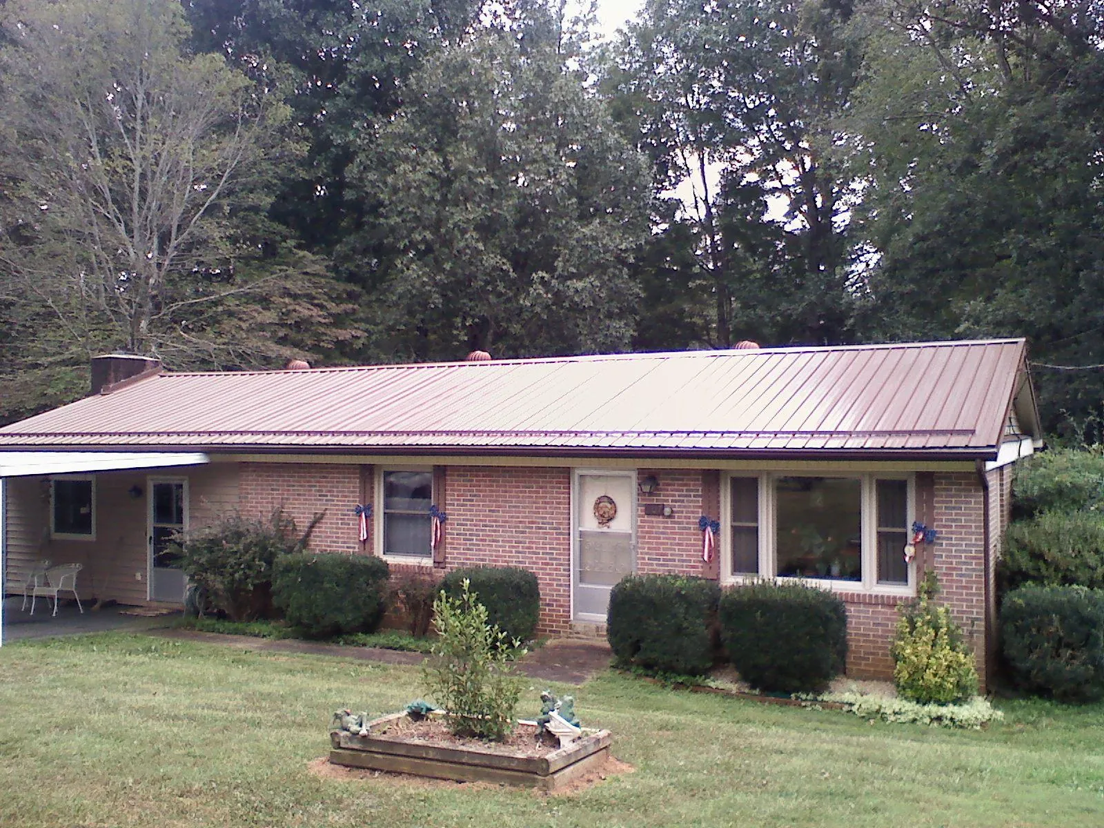 Bronze metal roof on a brick ranch home with a carport in Archbald