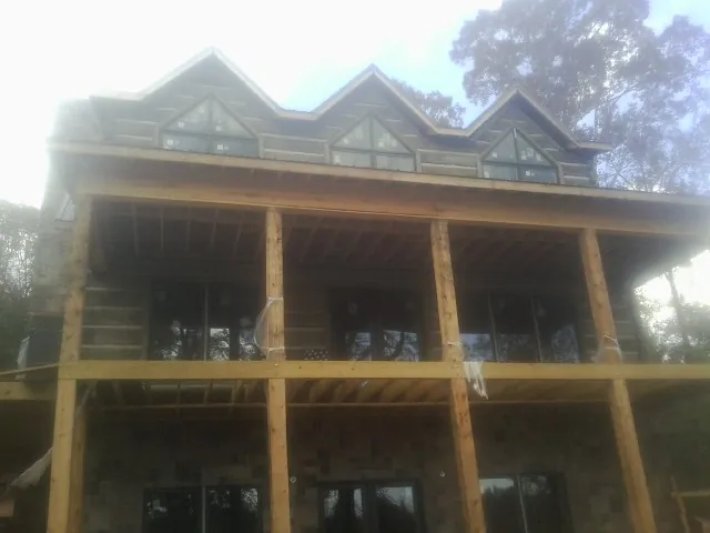 Dormers and porch framing on a large log home under construction — Roof Coating work by our crew in Archbald