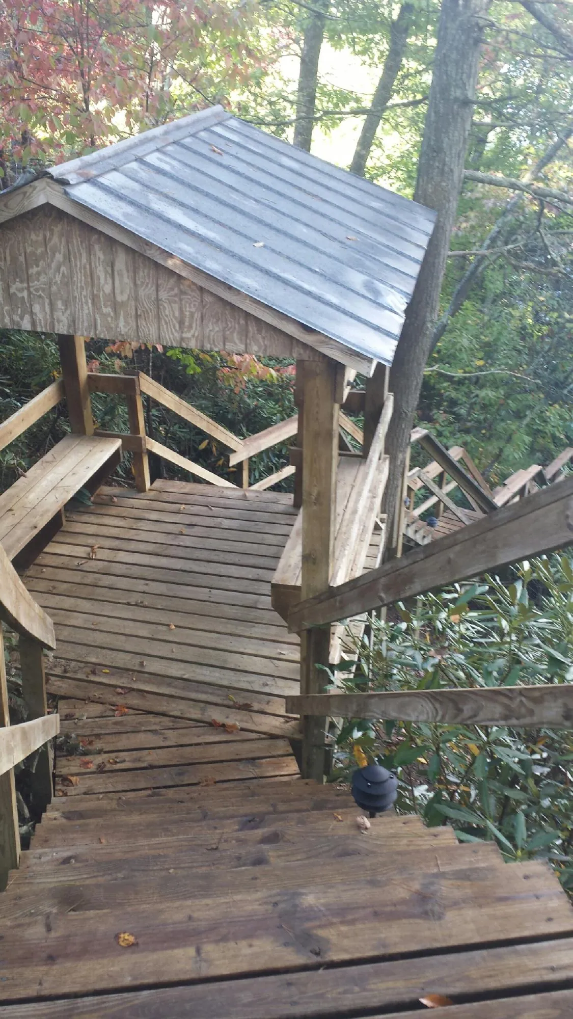 Metal roofed shelter over wooden steps on a wooded walkway — Skylight Repair & Installation work by our crew in Archbald