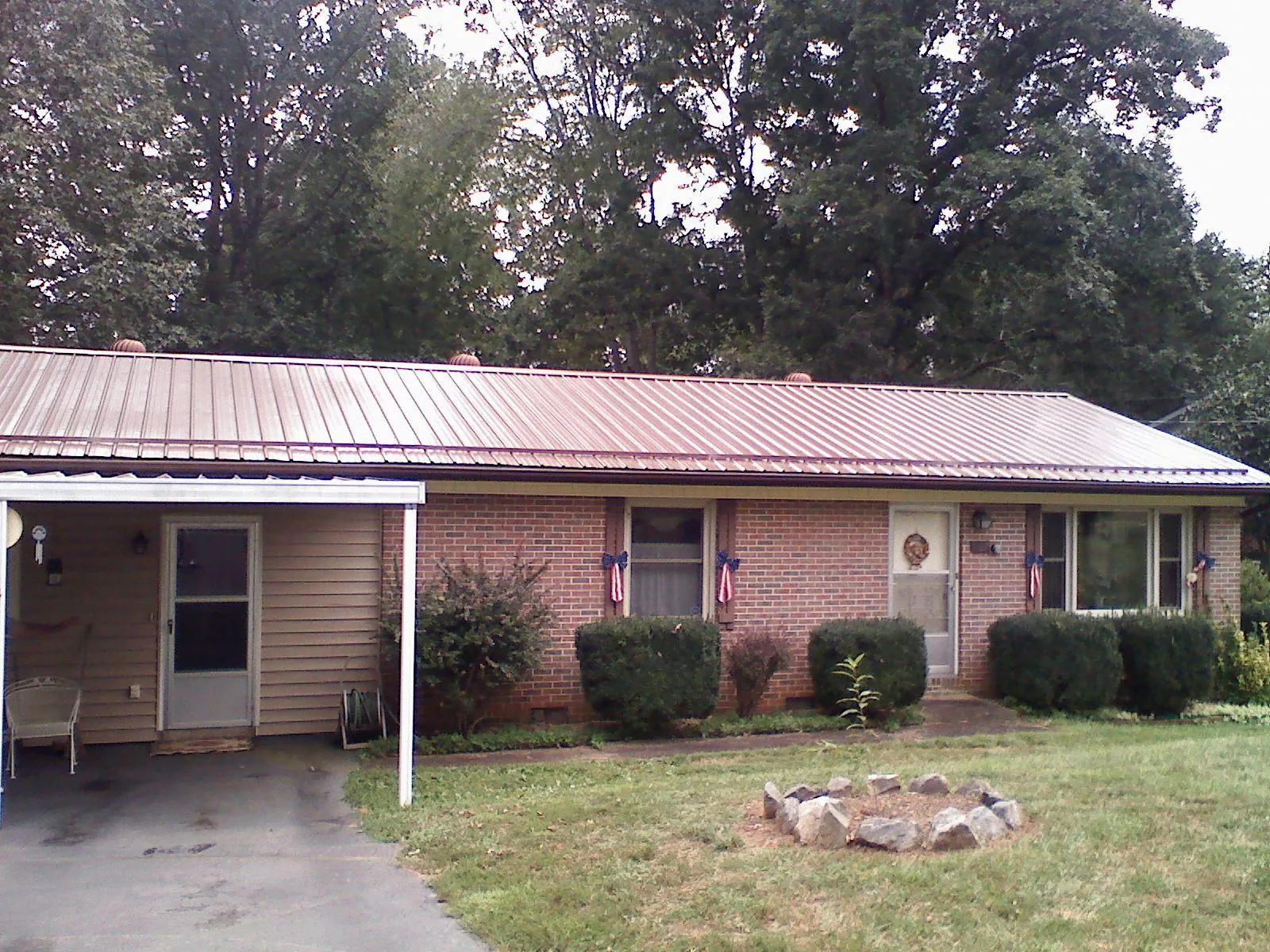 Bronze metal roof and carport on a brick ranch home — Roof Repair work by our crew in Archbald